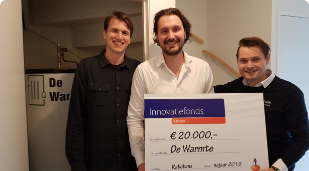Afbeelding van DeWarmte die de Robobank Innovatieprijs wint, waarbij medewerkers en vertegenwoordigers van het bedrijf de prijs trots presenteren.
